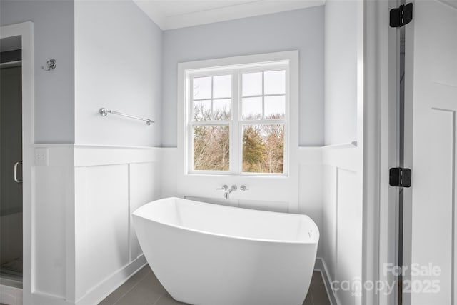 149 Beauchamp Oaks Ct, Advance, NC 27006 - bathroom with wainscoting, a stall shower, a freestanding tub, and tile patterned floors