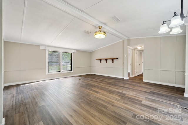 unfurnished living room with wood finished floors, a chandelier, and a decorative wall