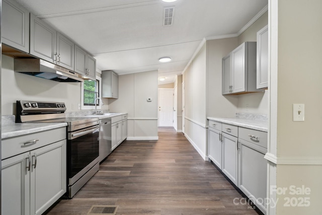 kitchen featuring appliances with stainless steel finishes, gray cabinetry, under cabinet range hood, light countertops, and ornamental molding