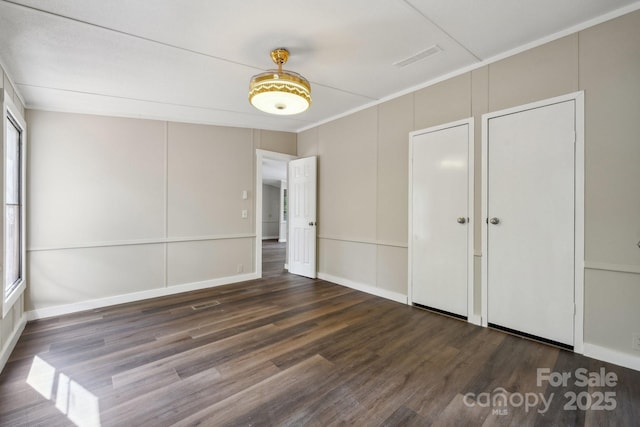 unfurnished bedroom featuring wood finished floors and baseboards