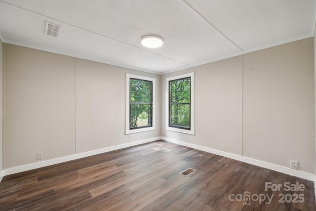 unfurnished room featuring dark wood-type flooring and baseboards