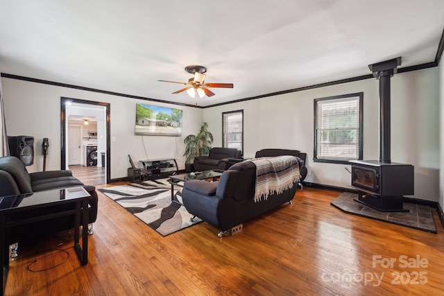 1917 Tom Sadler Rd, Charlotte, NC 28214 - living area with ornamental molding, a ceiling fan, wood finished floors, a wood stove, and washer / clothes dryer