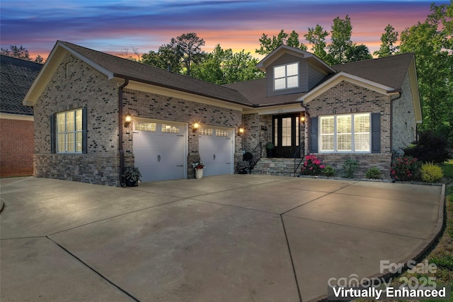 traditional home with driveway, a garage, stone siding, and brick siding