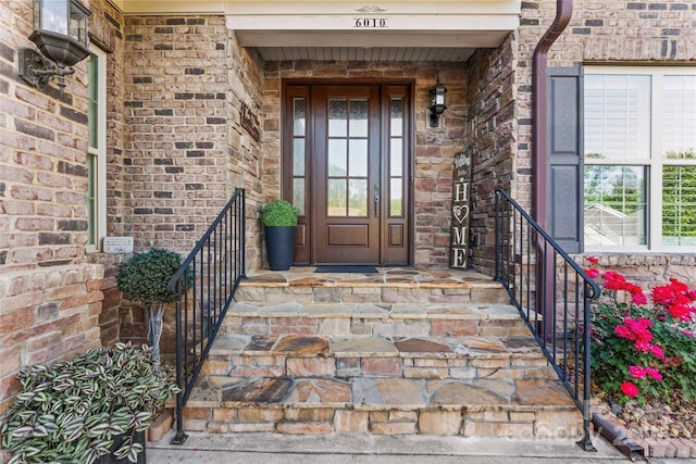 view of exterior entry featuring brick siding