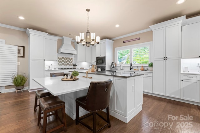 kitchen featuring premium range hood, ornamental molding, a chandelier, decorative backsplash, and black microwave