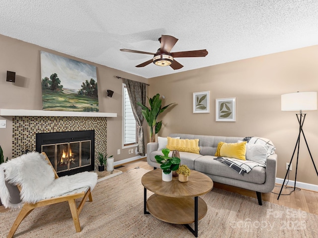 42 Hollybrook Dr, Asheville, NC 28803 - living room featuring wood finished floors, a tile fireplace, a ceiling fan, and a textured ceiling