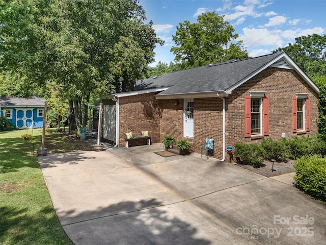 8544 Houston Ridge Rd, Charlotte, NC 28277 - view of front facade with brick siding, roof with shingles, a patio area, and a front lawn