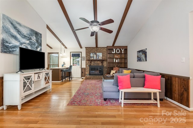 8544 Houston Ridge Rd, Charlotte, NC 28277 - living room featuring ceiling fan, light wood-type flooring, a brick fireplace, and a wainscoted wall