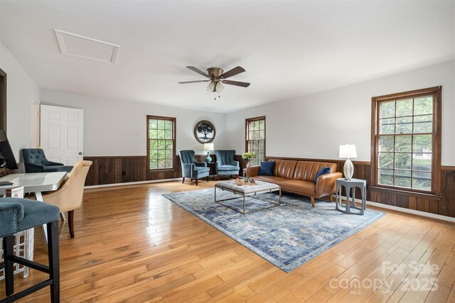 8544 Houston Ridge Rd, Charlotte, NC 28277 - living room featuring a wainscoted wall, light wood-type flooring, attic access, wood walls, and a ceiling fan