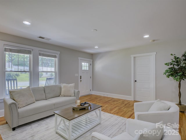 living room with light wood finished floors, baseboards, and recessed lighting