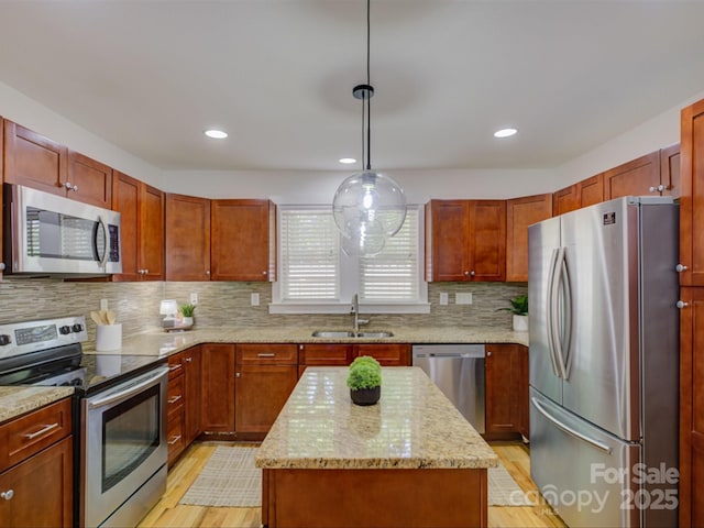 kitchen featuring appliances with stainless steel finishes, a sink, light wood-type flooring, a kitchen island, and recessed lighting