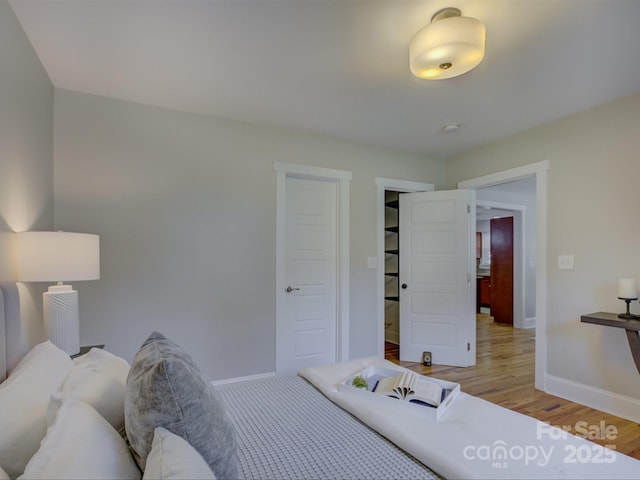 bedroom with baseboards, light wood-style floors, and a closet