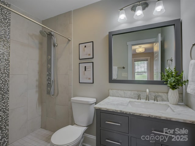 full bathroom with toilet, vanity, and a tile shower