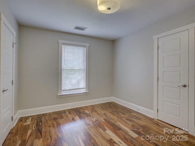empty room with baseboards and wood finished floors