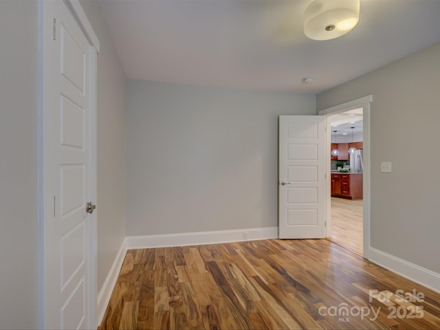 spare room with wood finished floors and baseboards