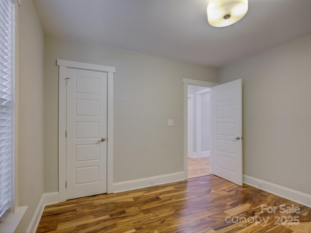 spare room featuring wood finished floors and baseboards