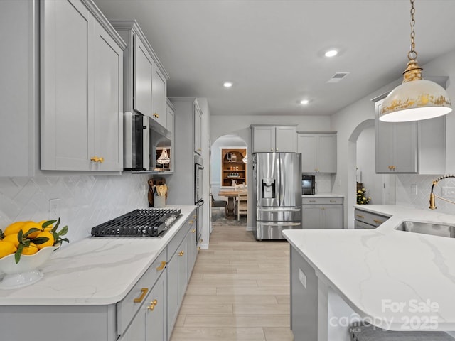 5581 Soft Shell Dr, Lancaster, SC 29720 - kitchen featuring stainless steel appliances, arched walkways, gray cabinets, a sink, and recessed lighting