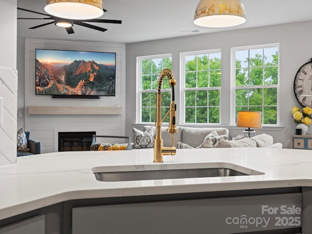 5581 Soft Shell Dr, Lancaster, SC 29720 - kitchen with a sink, open floor plan, a large fireplace, ceiling fan, and light stone countertops