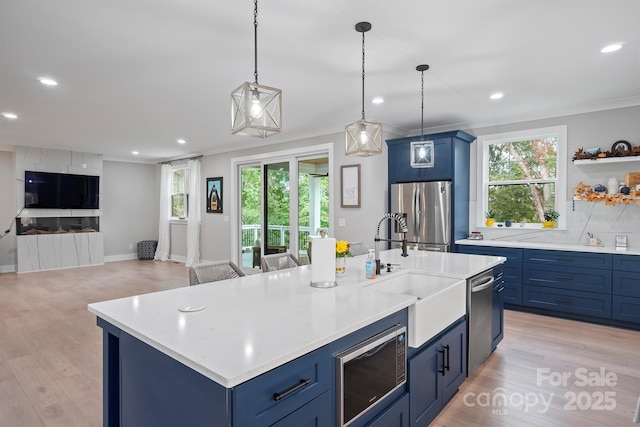 685 Knollcrest Dr NE, Concord, NC 28025 - kitchen featuring stainless steel appliances, blue cabinets, a sink, crown molding, and light countertops