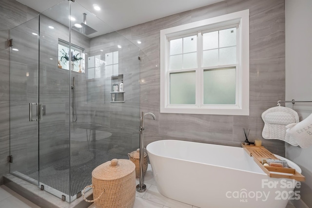 685 Knollcrest Dr NE, Concord, NC 28025 - bathroom with a shower stall, a soaking tub, tile walls, and tile patterned floors