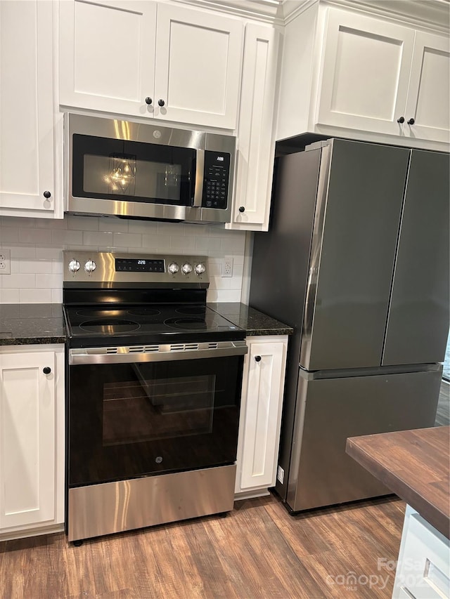 8222 Madison Ln, Hickory, NC 28602 - kitchen with appliances with stainless steel finishes, white cabinets, wood finished floors, and decorative backsplash