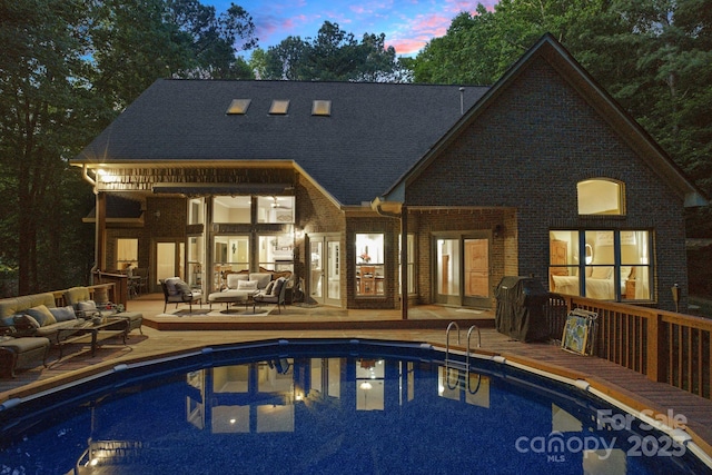 131 Sierra Woods Dr, Troutman, NC 28166 - back of house with outdoor lounge area, an outdoor pool, brick siding, and a wooden deck