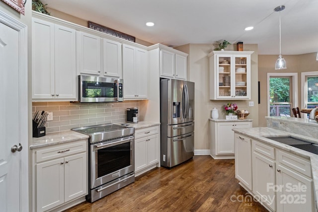 131 Sierra Woods Dr, Troutman, NC 28166 - kitchen featuring appliances with stainless steel finishes, a sink, white cabinetry, glass insert cabinets, and tasteful backsplash