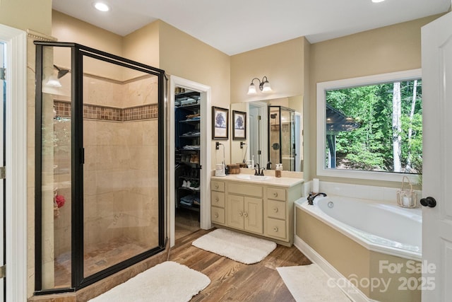 131 Sierra Woods Dr, Troutman, NC 28166 - full bathroom featuring a shower stall, vanity, wood finished floors, a garden tub, and recessed lighting