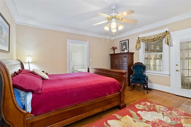 bedroom featuring wood finished floors, crown molding, ceiling fan, and baseboards