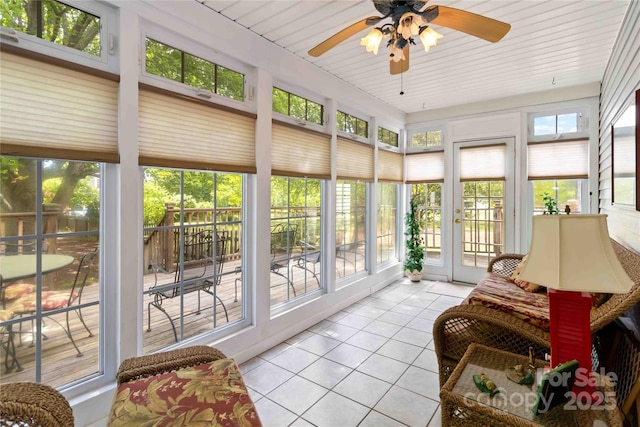 sunroom featuring tile patterned flooring, french doors, a ceiling fan, and plenty of natural light