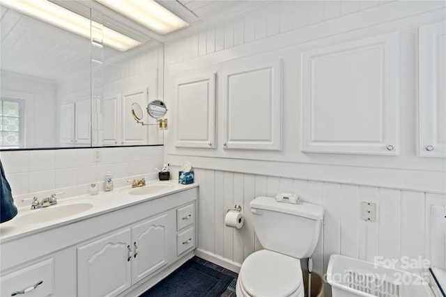 bathroom featuring toilet and double vanity