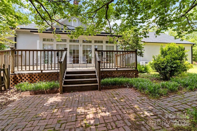 rear view of house featuring a deck and a chimney