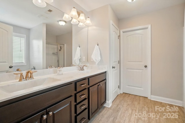 6314 Bluffton Ln, Midland, NC 28107 - bathroom featuring wood finished floors, a shower stall, double vanity, and baseboards