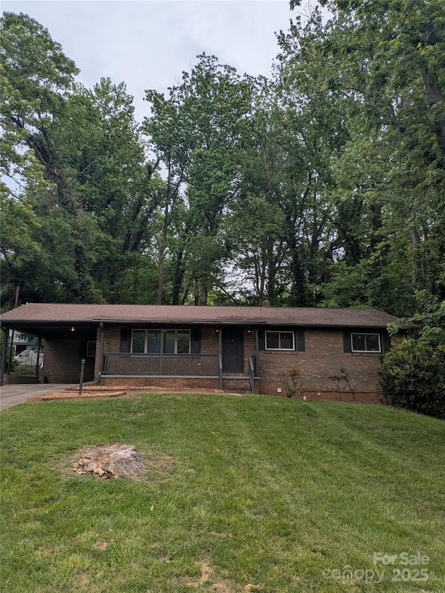 single story home featuring brick siding, a carport, a front yard, and driveway