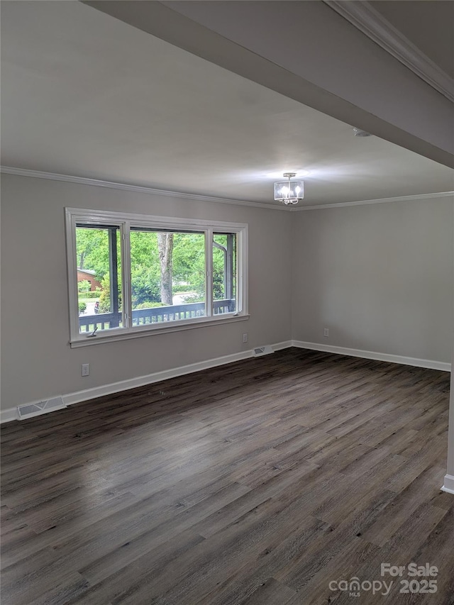 spare room featuring ornamental molding, plenty of natural light, a chandelier, dark wood-style floors, and baseboards