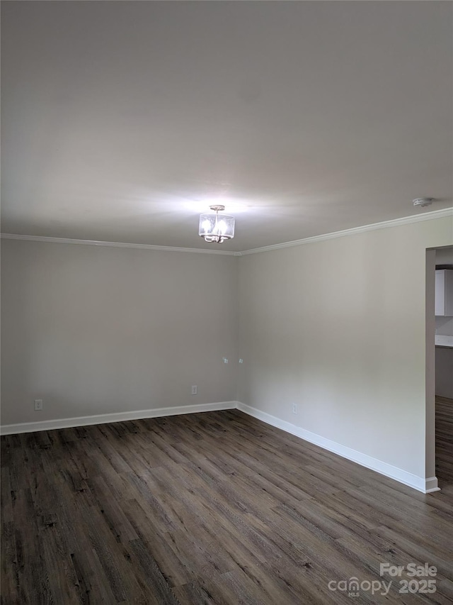 unfurnished room with crown molding, dark wood-type flooring, baseboards, a chandelier, and a smoke detector