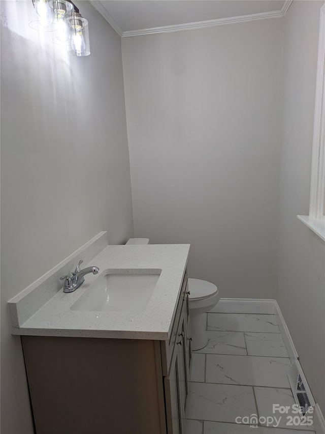 bathroom featuring vanity, marble finish floors, toilet, baseboards, and crown molding