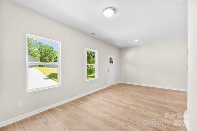 empty room with light wood-type flooring and baseboards