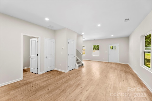unfurnished living room with stairs, light wood-type flooring, baseboards, and recessed lighting