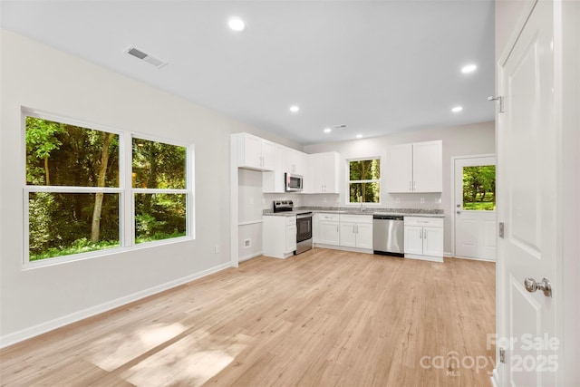 kitchen featuring appliances with stainless steel finishes, light wood-style floors, white cabinetry, baseboards, and recessed lighting