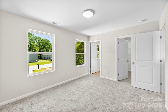 unfurnished bedroom with baseboards, carpet floors, and a spacious closet