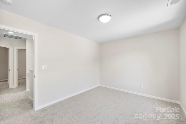 empty room with carpet floors, baseboards, and a smoke detector