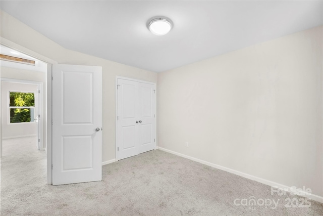 unfurnished bedroom with carpet, baseboards, and a closet