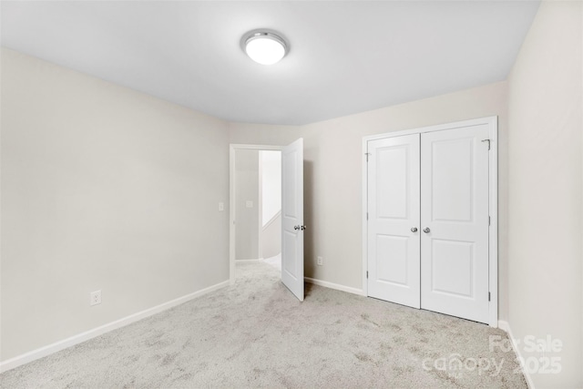 unfurnished bedroom featuring carpet flooring, baseboards, and a closet