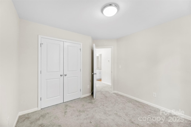 unfurnished bedroom featuring carpet flooring, baseboards, and a closet