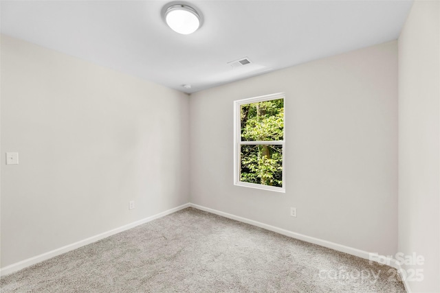carpeted empty room featuring baseboards