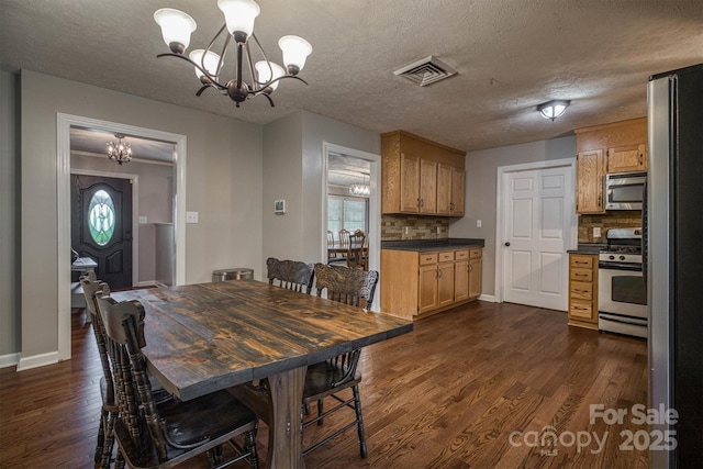 107 Pete Brittain Rd, Morganton, NC 28655 - dining space featuring a chandelier, dark wood-type flooring, healthy amount of natural light, baseboards, and a textured ceiling