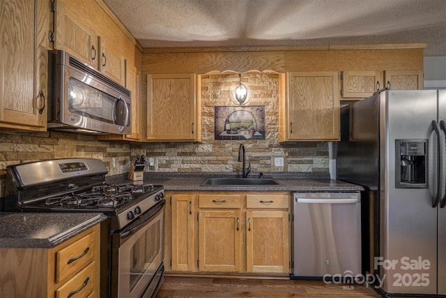 107 Pete Brittain Rd, Morganton, NC 28655 - kitchen featuring stainless steel appliances, a sink, a textured ceiling, dark countertops, and dark wood-type flooring