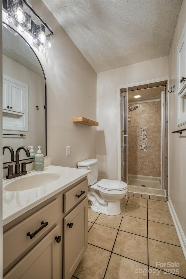 107 Pete Brittain Rd, Morganton, NC 28655 - full bathroom with a textured ceiling, tile patterned floors, a shower stall, toilet, and vanity