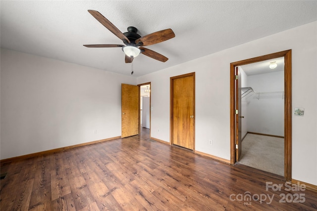 234 Snyder Farm Rd, Waynesville, NC 28786 - unfurnished bedroom with baseboards, wood finished floors, a walk in closet, and a ceiling fan